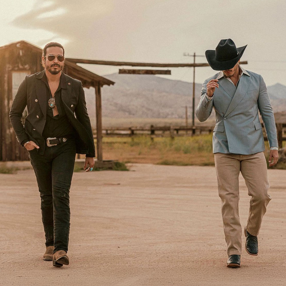 Two men walking in the desert wearing Tony Lama boots.